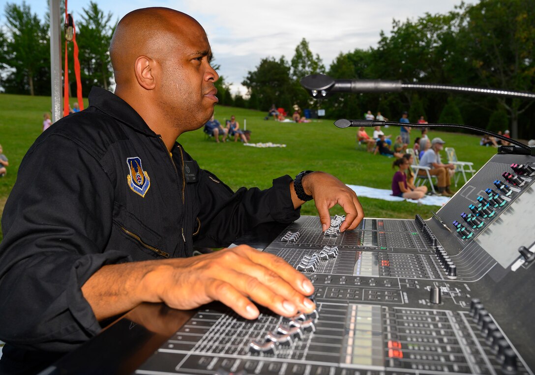 Tech. Sgt. Kelcey McDonald, Flight One audio engineer, works the soundboard  during a performance by the Air Force Band of Flight’s rock ensemble Aug. 13, 2021, at Centerville Community Amphitheater in Stubbs Park, Centerville, Ohio. McDonald is just as integral to the Air Force rock band as any of the musicians on stage. (U.S. Air Force photo by R.J. Oriez)