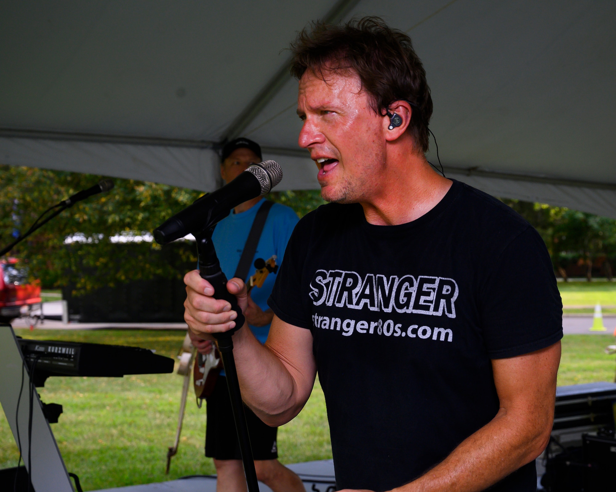 Jeff Stevens, lead singer for Stranger, performs at a block party Aug. 12, 2021, put on by the 88th Force Support Squadron in the historic Brick Quarters housing area at Wright-Patterson Air Force Base, Ohio. The band, specializing in music from the 1980s, provided a free concert for attendees. (U.S. Air Force photo by R.J. Oriez)