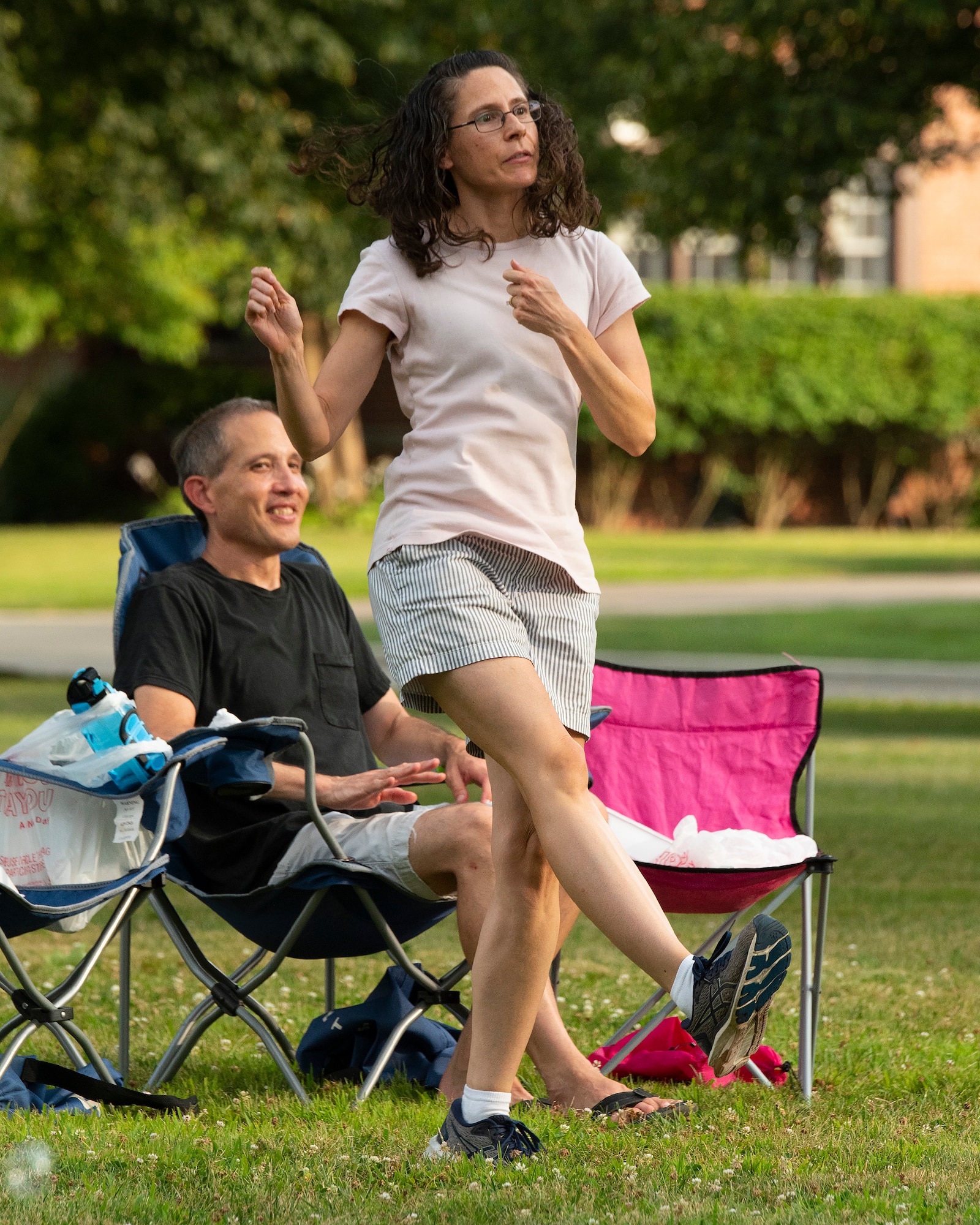 Melissa  Nishikawa dances as her husband, Col. Brett Nishikawa, 711th Human Performance Wing, watches Aug. 12, 2021, at a block party by Turtle Pond in the historic Brick Quarters housing area at Wright-Patterson Air Force Base, Ohio. The event, put on by the 88th Force Support Squadron, was the second in a summer series for the Wright-Patt community, with the finale scheduled Aug. 26. (U.S. Air Force photo by R.J. Oriez)