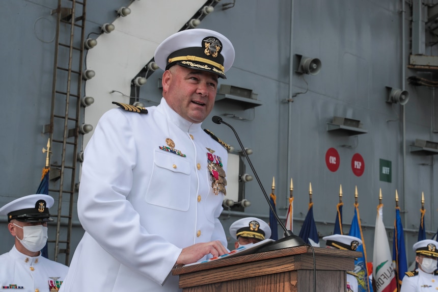 Capt. Walt. M. Slaughter, outgoing commanding officer of the aircraft carrier USS Abraham Lincoln, delivers remarks during a change of command ceremony held on the flight deck.