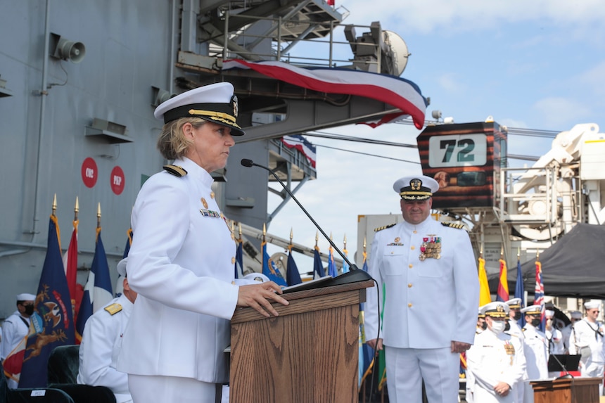 Capt. Amy Bauernschmidt,  incoming commanding officer of the aircraft carrier USS Abraham Lincoln (CVN 72), reads her orders during a change of command ceremony held on the flight deck.