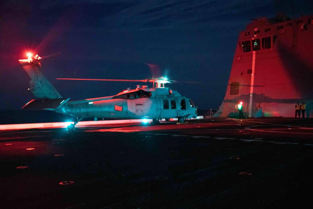 ATLANTIC OCEAN (Aug. 17, 2021) A Sailor assigned to the “Chargers” of Helicopter Sea Combat Squadron (HSC) 26, Detachment 5, directs pilots to shut down an MH-60S Sea Hawk helicopter on the flight deck of the San Antonio-class amphibious transport dock ship USS Arlington (LPD 24).