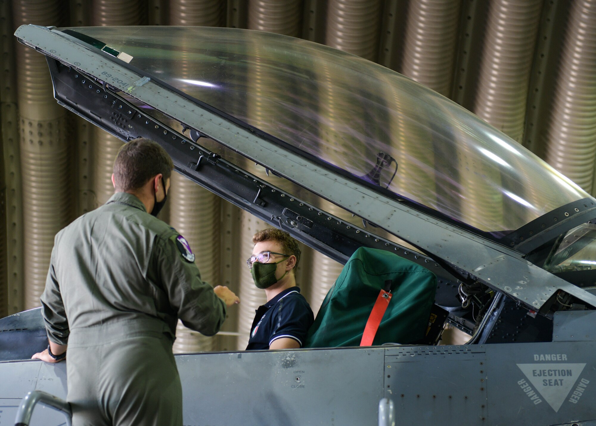 U.S. Air Force 1st Lt. Ian Bonner, 510th Fighter Squadron F-16 Fighting Falcon pilot, briefs Mirko Zanni, 2020 Summer Olympics weightlifting bronze medalist winner, about an F-16 at Aviano Air Base, Italy, Aug. 19, 2021. Mirko, a 2020 Summer Olympics weightlifting bronze medalist winner, attended a powerlifting competition and toured different facilities on base including the Air Control Tower and an F-16 Fighting Falcon. (U.S. Air Force photo by Senior Airman Brooke Moeder)