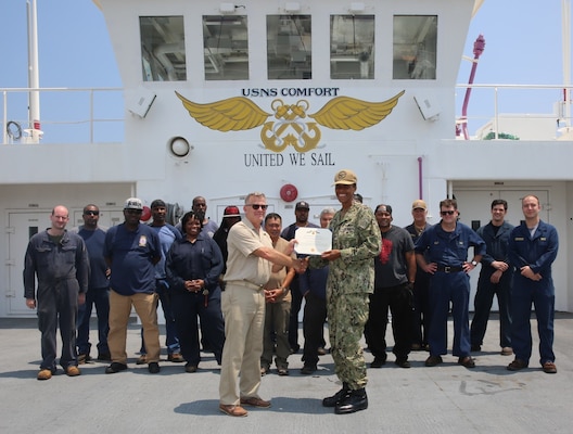 Capt. Janice G. Smith, Commodore, Military Sealift Command Atlantic, presents the Armed Forces Civilian Service Medal to Capt. Andrew Lindey, master of USNS Comfort.