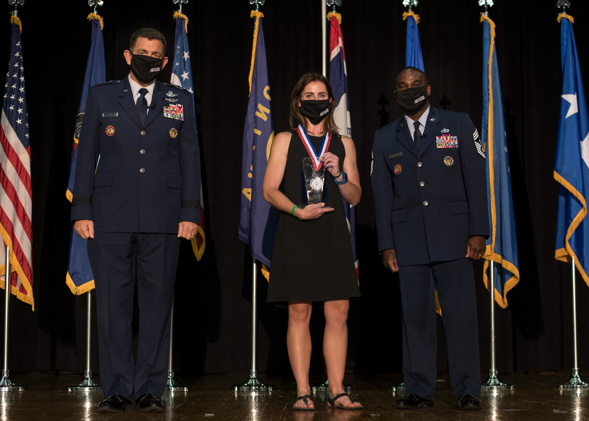 Ms. Jennifer Weir, wife of U.S. Air Force Master Sgt. Tyler Weir, 120th Airlift Wing, Montana National Guard, poses for a photo with Lt. Gen. Michael A. Loh, left, director, Air National Guard (ANG), and Chief Master Sgt. Maurice L. Williams, command chief, ANG, during the Outstanding Airmen of the Year ceremony at Joint Base Andrews, Maryland, Aug. 19, 2021. Master Sgt. Tyler Weir, who passed away in early 2021, was recognized as the ANG’s Non-commissioned Officer of the Year during Focus on the Force Week 2021—an annual event hosted by the ANG command chief that highlights professional development and celebrates the accomplishments of the top performing members of the enlisted corps. (U.S. Air National Guard photo by Tech. Sgt. Morgan R. Whitehouse)