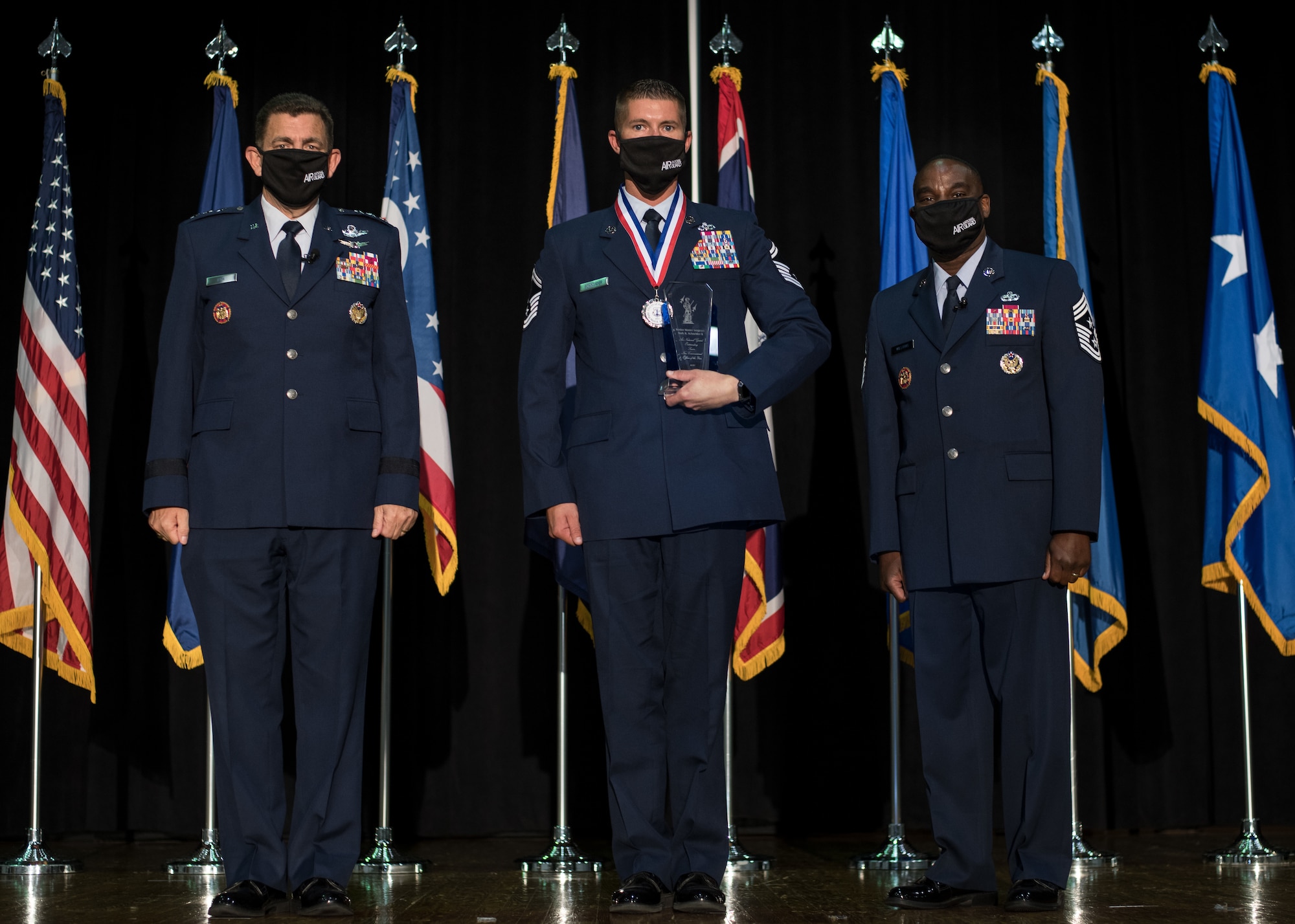 U.S. Air Force Senior Master Sgt. Mark Schneider II, with the 179th Airlift Wing, Ohio National Guard, poses for a photo with Lt. Gen. Michael A. Loh, left, director, Air National Guard (ANG), and Chief Master Sgt. Maurice L. Williams, command chief, ANG, during the Outstanding Airmen of the Year ceremony at Joint Base Andrews, Maryland, Aug. 19, 2021. Schneider was recognized as the ANG’s Senior Non-commissioned Officer of the Year during Focus on the Force Week 2021—an annual event hosted by the ANG command chief that highlights professional development and celebrates the accomplishments of the top performing members of the enlisted corps. (U.S. Air National Guard photo by Tech. Sgt. Morgan R. Whitehouse)