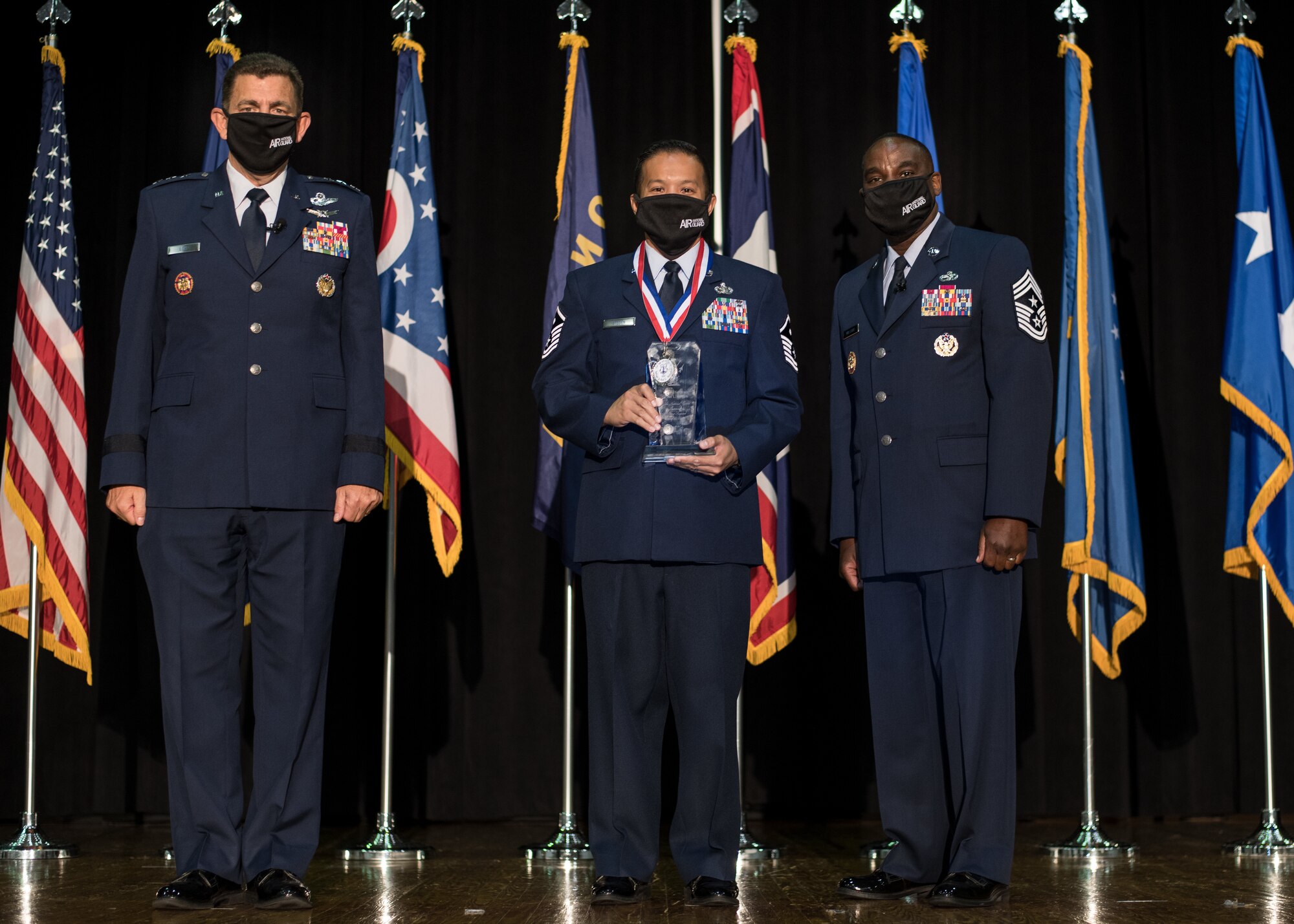 U.S. Air Force Master Sgt. John Stegen, center, with the 153rd Airlift Wing, Wyoming National Guard, poses for a photo with Lt. Gen. Michael A. Loh, left, director, Air National Guard (ANG), and Chief Master Sgt. Maurice L. Williams, command chief, ANG, during the Outstanding Airmen of the Year ceremony at Joint Base Andrews, Maryland, Aug. 19, 2021. Stegen was recognized as the ANG’s First Sergeant of the Year during Focus on the Force Week 2021—an annual event hosted by the ANG command chief that highlights professional development and celebrates the accomplishments of the top performing members of the enlisted corps. (U.S. Air National Guard photo by Tech. Sgt. Morgan R. Whitehouse)