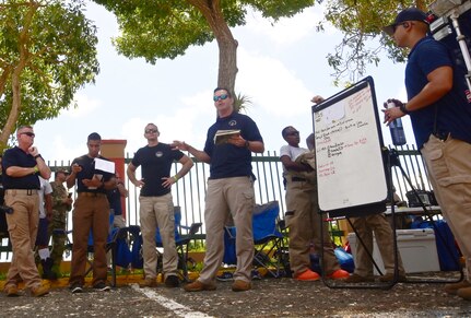 33rd Weapons of Mass Destruction Civil Support Team members, D.C. National Guard, discuss response actions with fellow WMD-CST members, fire department and local government in response to a potential chemical, biological, or radiological threat while participating in a training event in the municipality of Carolina in Puerto Rico, Aug. 18, 2021. The training scenarios include response, evaluation, testing, and securing the area of contamination. The members are made up of soldiers and airmen from the 33rd WMD-CST, along with Texas, North Carolina, West Virginia, Puerto Rico and the District of Columbia Fire and Emergency Management Service.