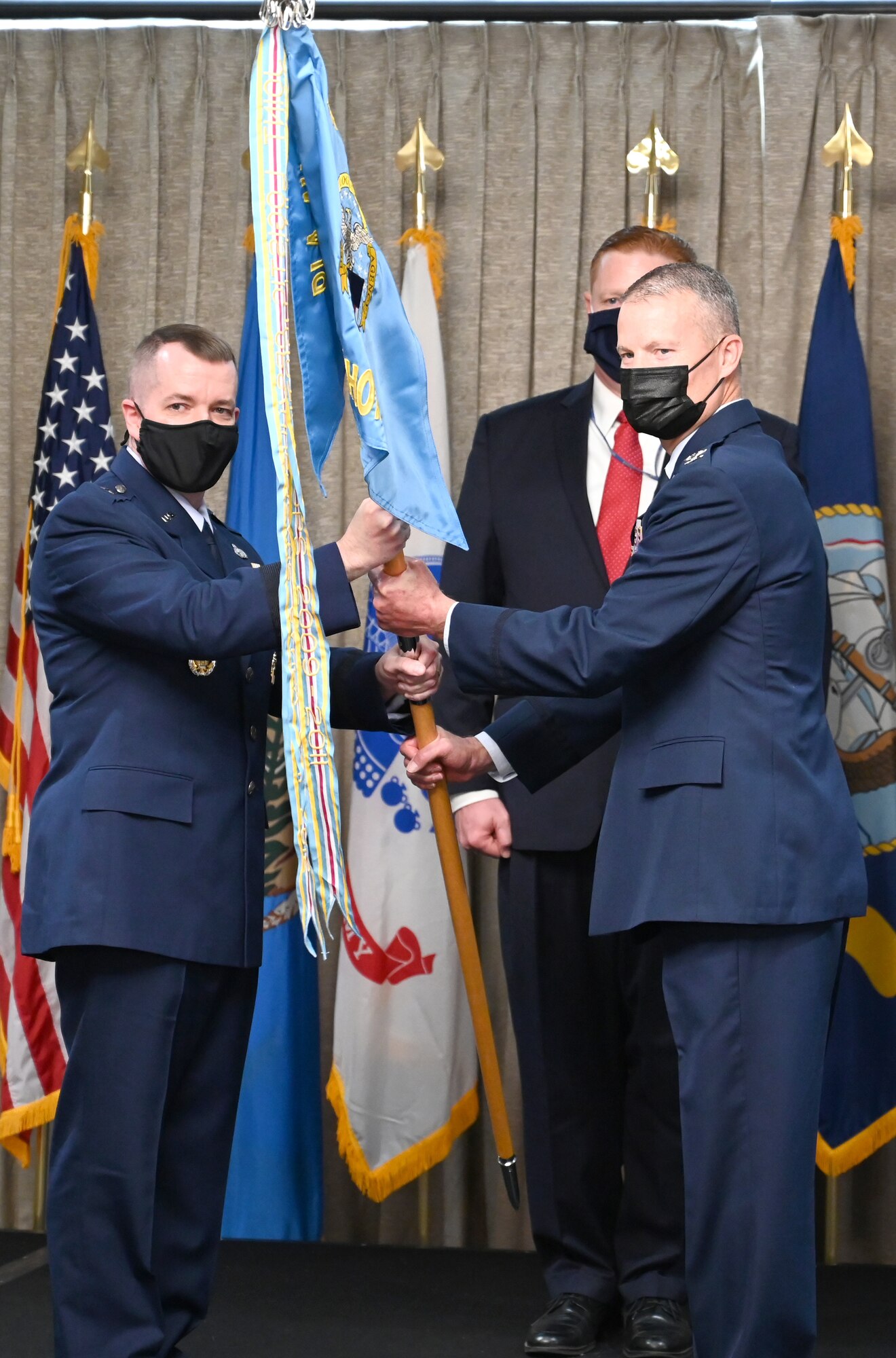 Two men looking at the camera, holding a flag