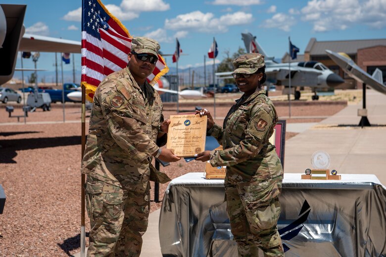 Staff Sgt. Michelle L. Guilford, Airman Leadership School graduate, accepts the distinguished graduate award during the graduation of ALS class 21-7, Aug. 19, 2021, on Holloman Air Force Base, New Mexico. The distinguished graduate award is presented to the top ten-percent of graduates for their performance in academic evaluations and demonstration of leadership. (U.S. Air Force photo by Airman 1st Class Jessica Sanchez)