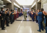 Ochsner Lafayette General Medical Center staff welcome a medical support team from Navy Medicine Readiness and Training Command Bethesda as they enter the hospital to begin their in-processing during COVID-19 response operations in Lafayette, Louisiana, Aug. 18, 2021.