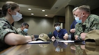 Medical providers from Navy Medicine Readiness and Training Command Bethesda speak with Jacob Smith, the clinical nurse manager at Ochsner Lafayette General Medical Center, during their in- processing for COVID-19 response operations in Lafayette, Louisiana, Aug. 18, 2021.