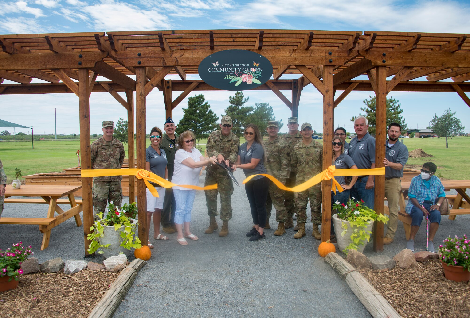 97th Air Mobility Wing members gather for a ribbon cutting ceremony for the opening of the Community Garden at Altus Air Force Base, Oklahoma, Aug. 20, 2021. After the ceremony was finished, individuals who rented plots could officially start planting their gardens. (U.S. Air Force photo by Airman 1st Class Amanda Lovelace)