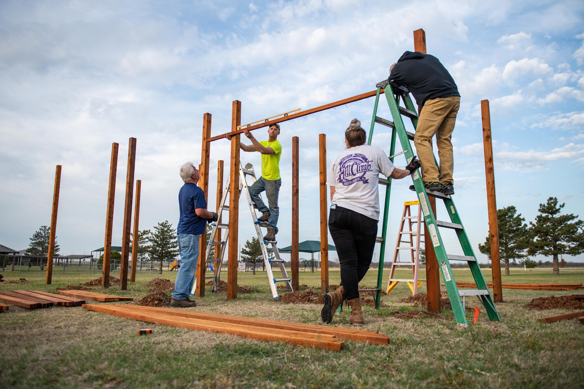 Members of the 97th Air Mobility Wing (AMW) construct a pergola for the community garden at Altus Air Force Base, Oklahoma, April 9, 2021. The garden took a total of 6 months to complete. (U.S. Air Force photo by Senior Airman Breanna Klemm)