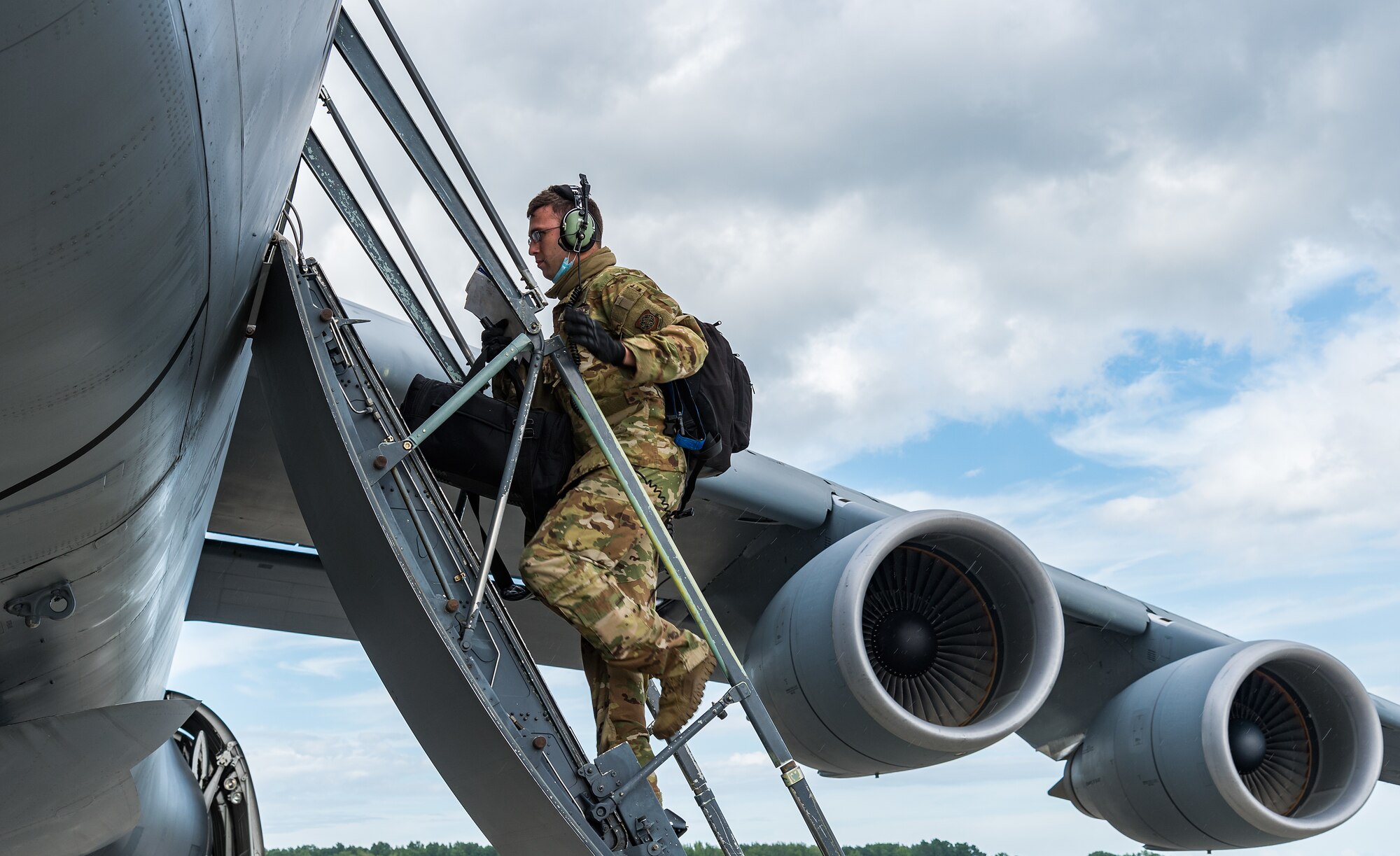 Staff Sgt. Broden McDonald, 9th Airlift Squadron flight engineer, climbs up to the crew entrance door of a C-5M Super Galaxy at Dover Air Force Base, Delaware, Aug. 18, 2021. The C-5M is a strategic transport aircraft and is the largest aircraft in the U.S. Air Force inventory. (U.S. Air Force photo by Roland Balik)