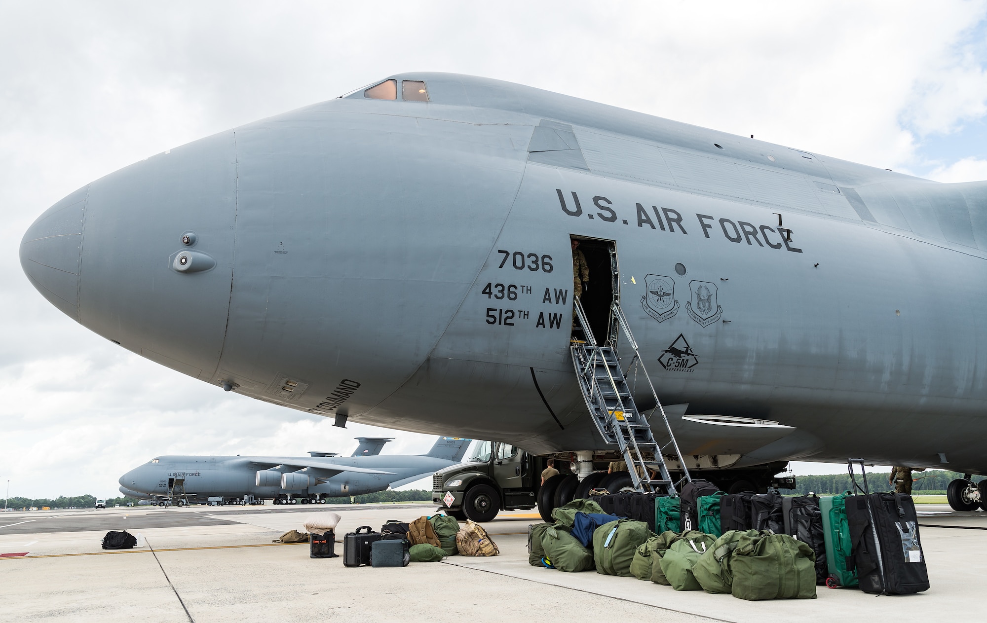 Aircrew luggage and professional gear bags sit near the bottom of the crew entrance door of a C-5M Super Galaxy prior to its departure from Dover Air Force Base, Delaware, Aug. 18, 2021. A Super Galaxy aircrew consists of a pilot, co-pilot, two flight engineers and three loadmasters on a normal mission. The C-5M is a strategic transport aircraft and is the largest aircraft in the U.S. Air Force inventory. (U.S. Air Force photo by Roland Balik)