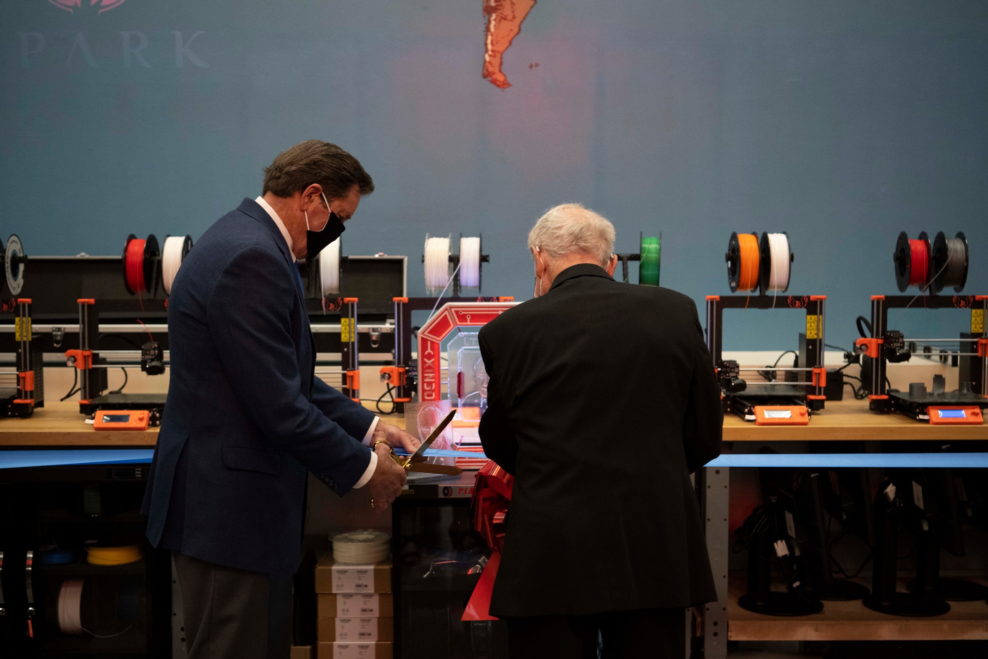 Two men cut a ribbon