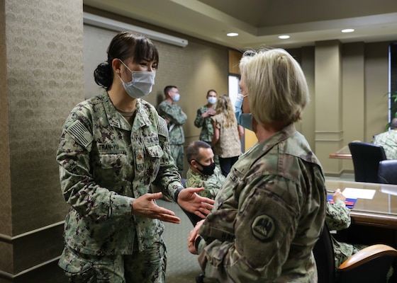U.S. Navy Lt. Cmdr. Diana Tran-Yu, left, the officer in charge of a medical support team from Navy Medicine Readiness and Training Command Bethesda speaks to U.S. Army Brig. Gen. Cindy Haygood, the dual-status commander for the state of Louisiana, during the medical support team’s initial in-processing at Ochsner Lafayette General Medical Center during COVID-19 response operations, Aug. 18, 2021.