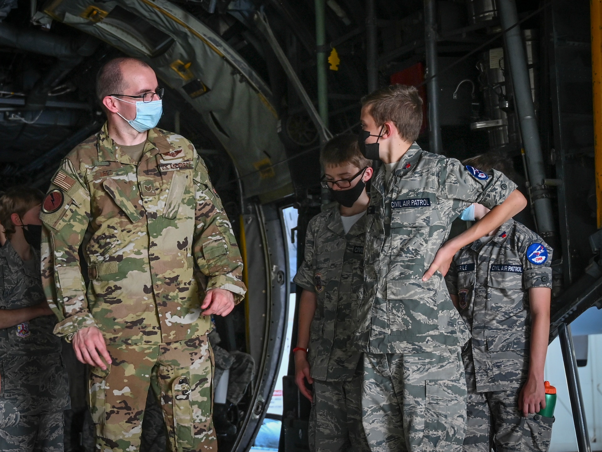 U.S. Air Force Staff Sgt. Radoslaw Kret, 118th Airlift Squadron loadmaster, talks with Civil Air Patrol cadets in the cargo bay of a 103rd Airlift Wing C-130H Hercules during a tour of Bradley Air National Guard Base in East Granby, Connecticut, Aug. 13, 2021. Cadets from the Connecticut Wing’s Danielson and Plainville squadrons got an up-close look at C-130H aircraft, the engines that power them, and learned about the 103rd Airlift Wing’s mission. (U.S. Air National Guard photo by Tech. Sgt. Steven Tucker)