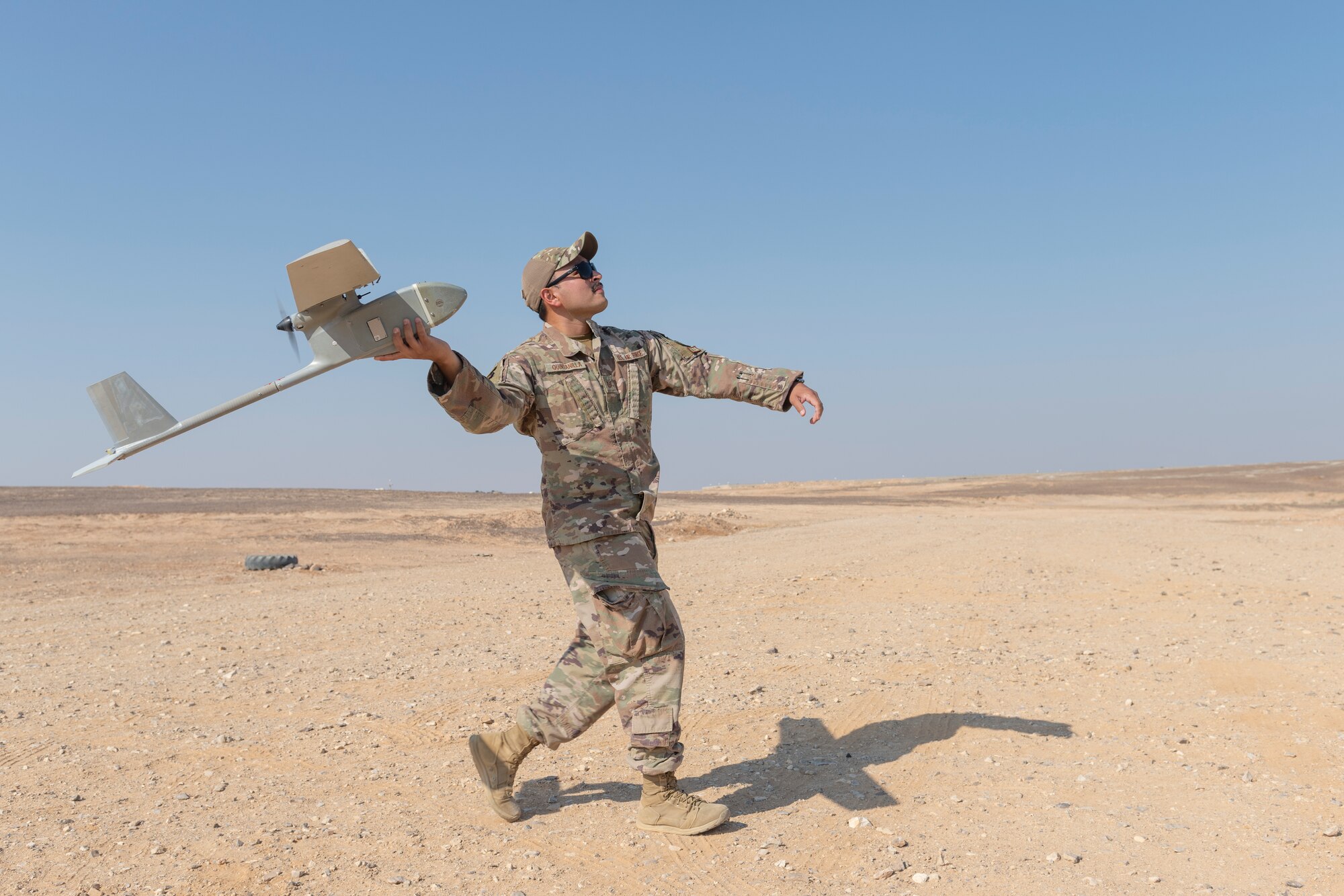 U.S. Air Force Tech. Sgt. Jerry Quintanilla, 332nd Expeditionary Security Forces Squadron noncommissioned officer in charge of Small Unmanned Aerial Systems, throws an RQ-11B Raven SUAS into the air August, 9, 2021, in an undisclosed location somewhere in Southwest Asia. SUAS operators perform flight exercises to enhance their experience in launching and controlling these drones for surveillance purposes. (U.S. Air Force photo by Senior Airman Cameron Otte)