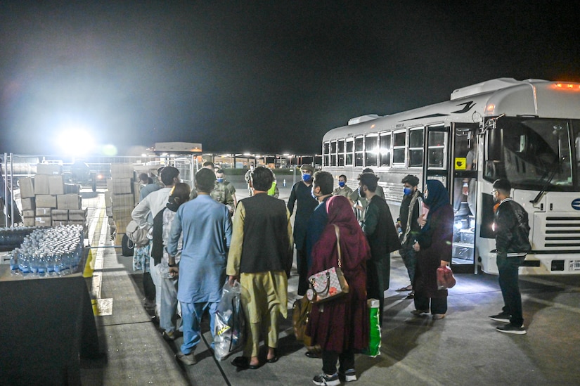 Evacuees depart buses.