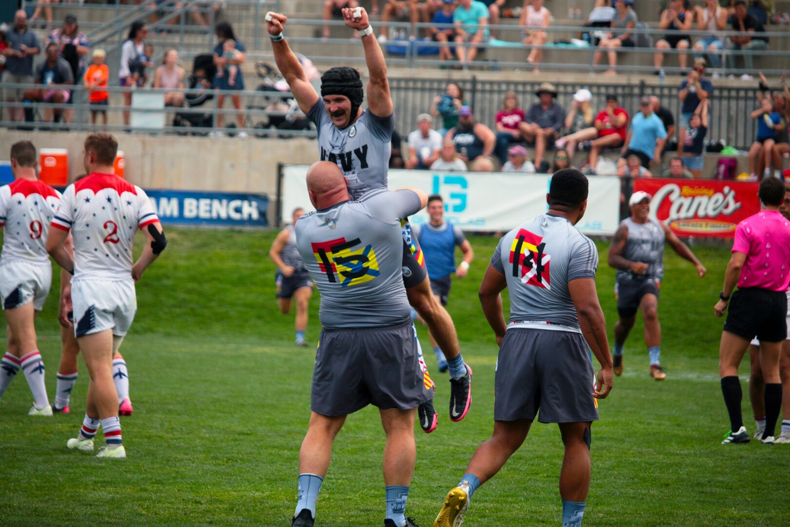 Petty Officer First Class James Irey of Marine Corps Support Facility New Orleans, La. lifts Lieut. Adam D'Amico of Navy Shipyard Portsmouth, Va. as Navy claims victory over Air Force. The 2021 Armed Forces Rugby Championship held in conjunction with the 2021 Rugbytown 7's Tournament, held from 20-22 August.  Service members from the Navy, Air Force (with Space Force personnel) and Coast Guard battle it out for gold.  (Department of Defense Photo, Released)