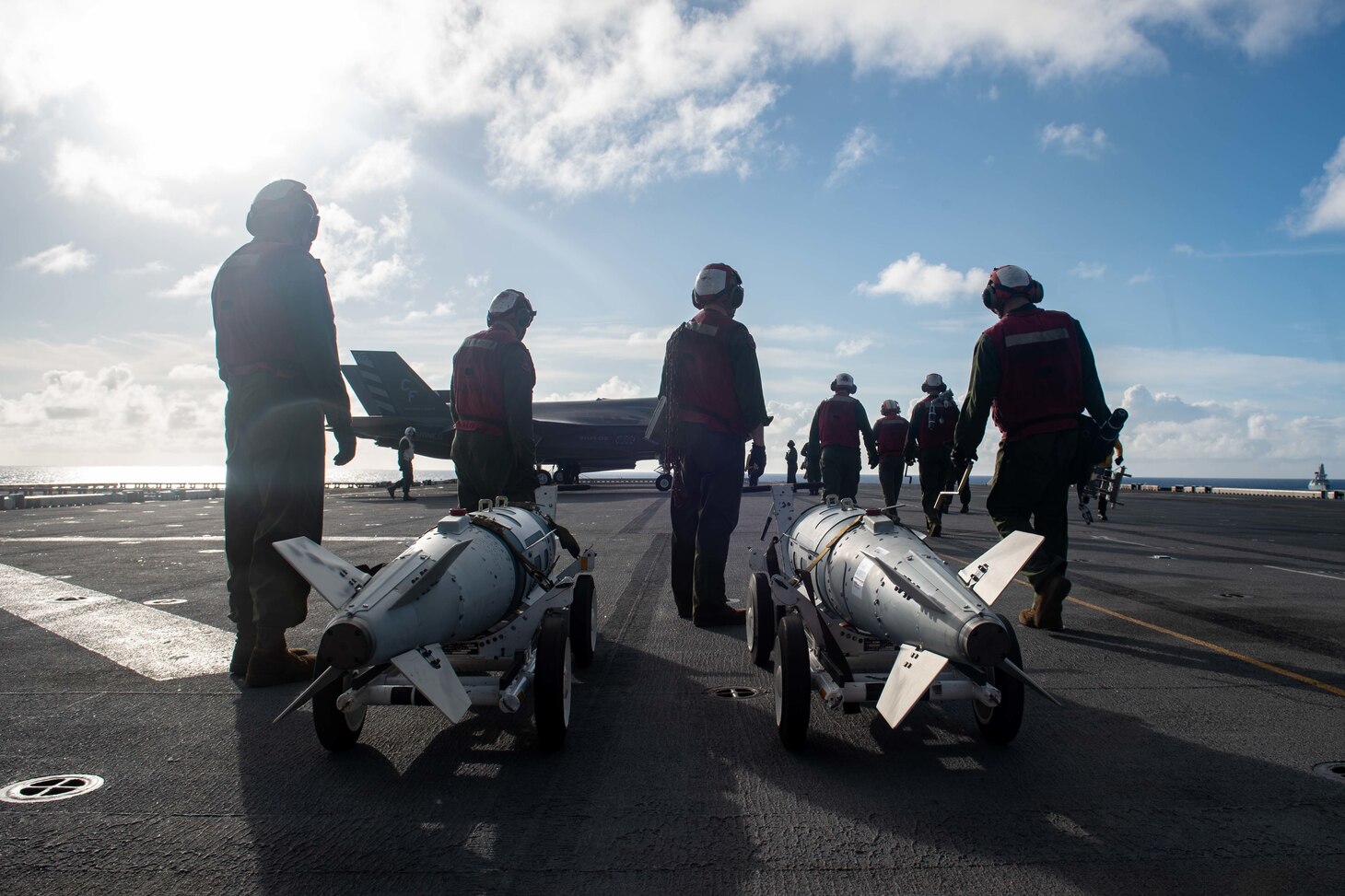 PHILIPPINE SEA (Aug. 20, 2021) Marines from the 31st Marine Expeditionary Unit (MEU) prepare to load inert ordnance into F-35B Lightning II fighter aircraft from Marine Fighter Attack Squadron (VMFA) 211, embarked on the Royal Navy aircraft carrier HMS Queen Elizabeth (R08), during flight operations between the forward-deployed amphibious assault ship USS America (LHA 6) and the Royal Navy. America, flagship of the America Expeditionary Strike Group, along with the 31st MEU, is operating in the U.S. 7th Fleet area of responsibility to enhance interoperability with allies and partners and serve as a ready response force to defend peace and stability in the Indo-Pacific region. (U.S. Navy photo by Mass Communication Specialist 3rd Class Matthew Cavenaile)