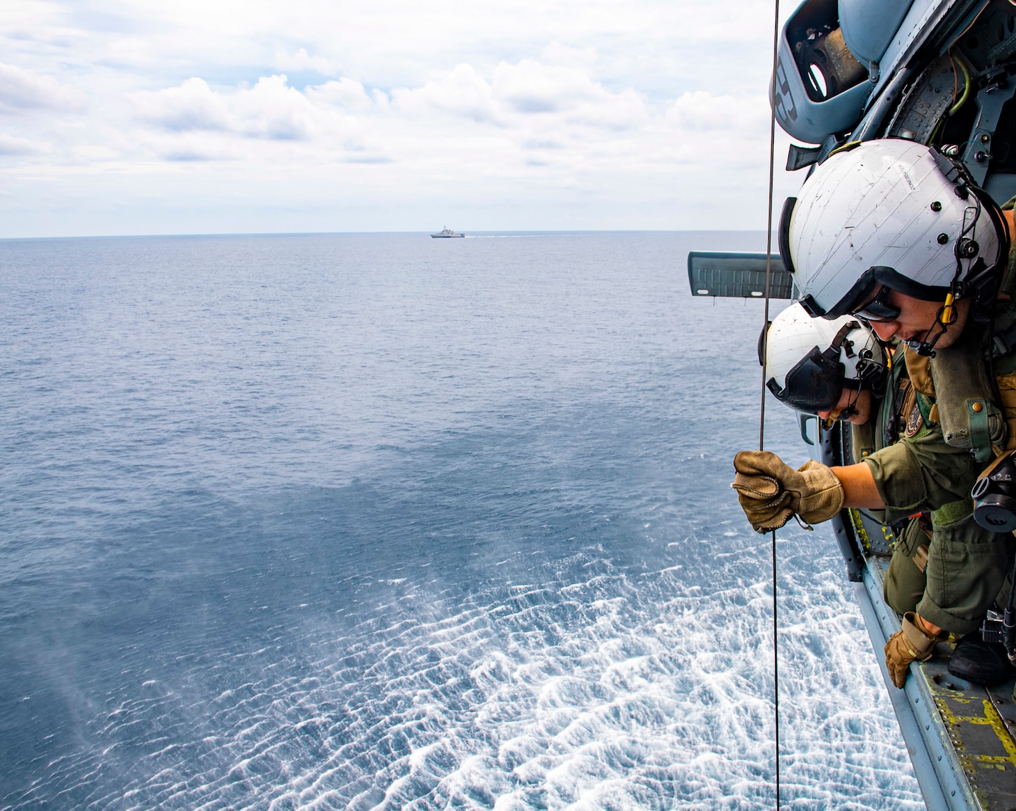 STRAIT OF MALACCA (AUG. 14, 2021) Naval Aircrewman (Helicopter) 2nd Class Nicolas Lopez from Artesia, Calif. and Brandon Matlock from Spokane, Wash., test the hoist system during flight operations inside of a MH-60S Seahawk helicopter assigned to the “Blackjacks” of Helicopter Sea Combat Squadron (HSC) 21 aboard the Independence-variant littoral combat ship USS Tulsa (LCS 16), Aug. 14, 2021. In its 20th year, SEACAT is a multilateral exercise designed to enhance cooperation among 21 participating Southeast Asian countries and provide mutual support and a common goal to address crises, contingencies, and illegal activities in the maritime domain in support of a free and open Indo-Pacific. (U.S. Navy photo by Mass Communication Specialist 3rd Class Richard Cho)