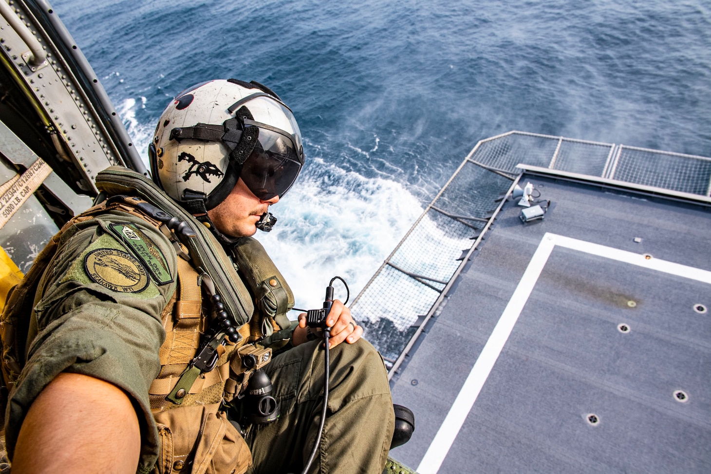 STRAIT OF MALACCA (AUG. 14, 2021) Naval Aircrewman (Helicopter) 1st Class Ryan Gee from Brighton, Mich., keeps a lookout during flight operations inside of a MH-60S Seahawk helicopter assigned to the “Blackjacks” of Helicopter Sea Combat Squadron (HSC) 21 aboard the Independence-variant littoral combat ship USS Tulsa (LCS 16), Aug. 14, 2021. In its 20th year, SEACAT is a multilateral exercise designed to enhance cooperation among 21 participating Southeast Asian countries and provide mutual support and a common goal to address crises, contingencies, and illegal activities in the maritime domain in support of a free and open Indo-Pacific. (U.S. Navy photo by Mass Communication Specialist 3rd Class Richard Cho)