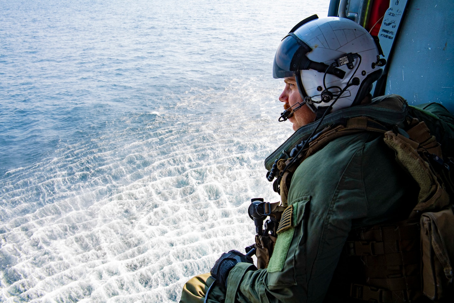 STRAIT OF MALACCA (AUG. 14, 2021) Naval Aircrewman (Helicopter) 1st Class Matthew Brickley from Peoria, Ariz., keeps a lookout during flight operations inside of a MH-60S Seahawk helicopter assigned to the “Blackjacks” of Helicopter Sea Combat Squadron (HSC) 21 aboard the Independence-variant littoral combat ship USS Tulsa (LCS 16), Aug. 14, 2021. In its 20th year, SEACAT is a multilateral exercise designed to enhance cooperation among 21 participating Southeast Asian countries and provide mutual support and a common goal to address crises, contingencies, and illegal activities in the maritime domain in support of a free and open Indo-Pacific. (U.S. Navy photo by Mass Communication Specialist 3rd Class Richard Cho)
