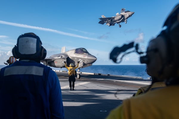PHILIPPINE SEA (Aug. 20, 2021) An F-35B Lightning II fighter aircraft from Marine Fighter Attack Squadron (VMFA) 211, embarked on the Royal Navy aircraft carrier HMS Queen Elizabeth (R08), lands on the flight deck of the forward-deployed amphibious assault ship USS America (LHA 6) during flight operations between and America and the Royal Navy. America, flagship of the America Expeditionary Strike Group, along with the 31st Marine Expeditionary Unit, is operating in the U.S. 7th Fleet area of responsibility to enhance interoperability with allies and partners and serve as a ready response force to defend peace and stability in the Indo-Pacific region. (U.S. Navy photo by Mass Communication Specialist 3rd Class Matthew Cavenaile)