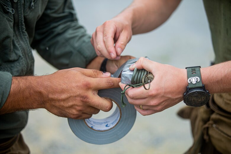 U.S. Marine Corps Sgt. Jose Gonzalez and Sgt. Timothy Allen, explosive ordnance disposal (EOD) technicians with Marine Corps Base Camp Butler EOD, prepare a drop-charge during a demolition range on Camp Hansen, Okinawa, Japan, Aug. 18, 2021. EOD technicians conducted a demolition range to increase proficiency in using nonstandard demolition techniques including drop-charge detonations, time-fuse setups and a robotics platform to remotely emplace charges. Gonzalez is a native of Port Chester, New York, and Allen is a native of Warsaw, Missouri. (U.S. Marine Corps photo by Lance Cpl. Alex Fairchild)