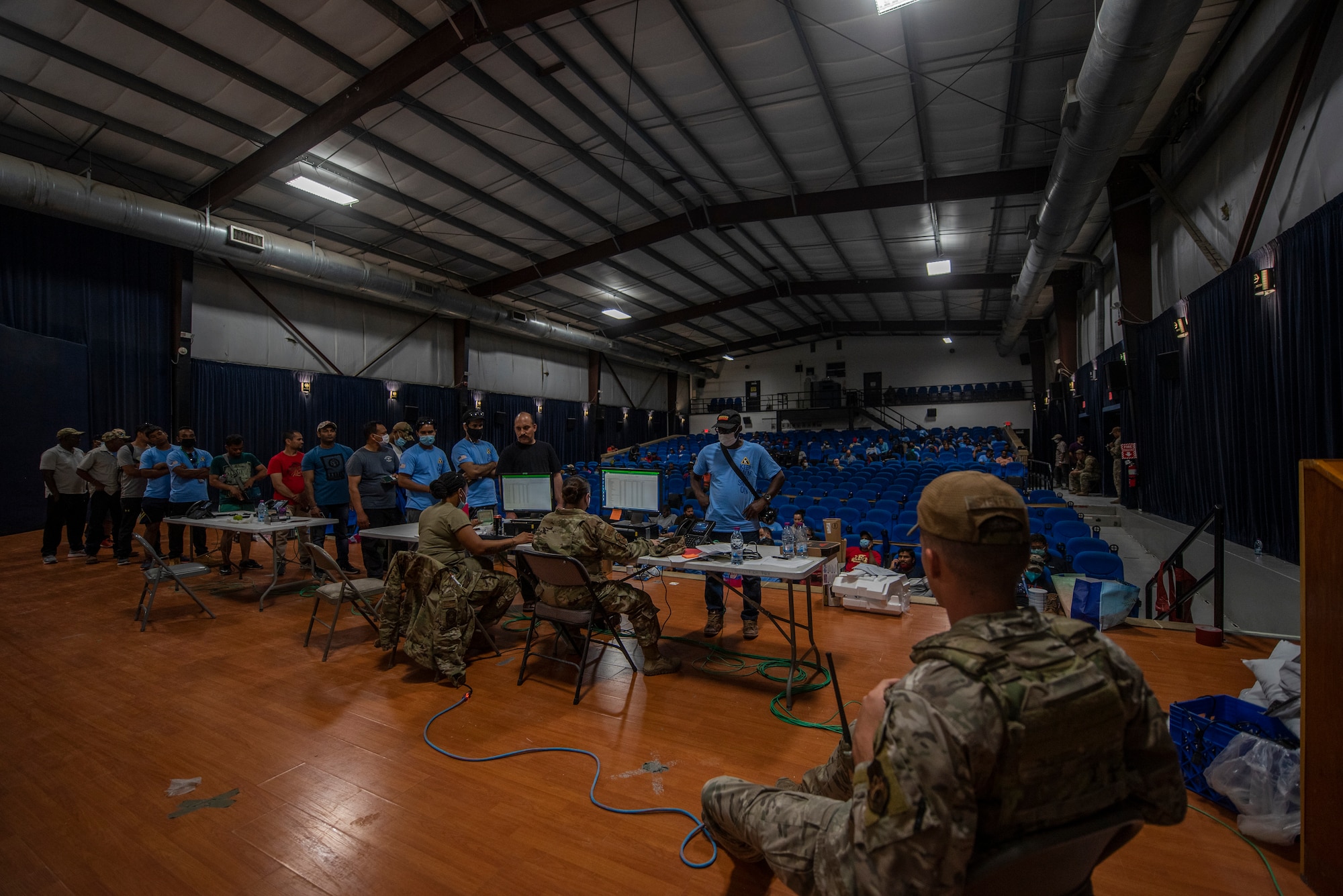 Members from the 379th Air Expeditionary Wing process Afghanistan evacuees at a camp theatre in the CENTCOM region, Aug. 20, 2021.