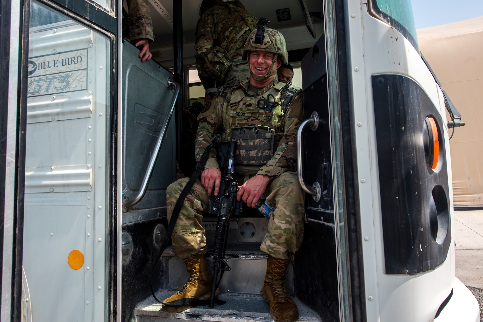 A service member waits on a bus prior to deploying to Afghanistan Aug. 19, 2021, at Al Udeid Air Base, Qatar.