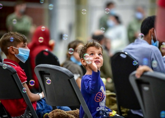 n Afghan child evacuee plays with bubbles at Naval Air Station Sigonella, Aug. 22, 2021.