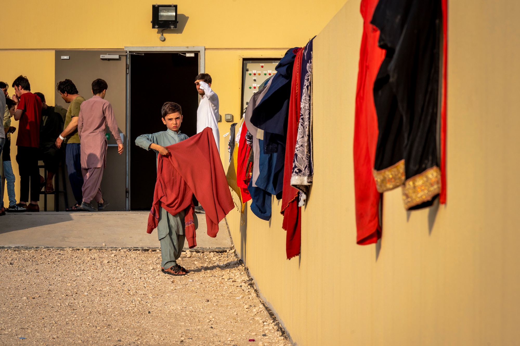 A child who evacuated Afghanistan sets clothes out to dry Aug. 21, 2021, in an undisclosed location somewhere in Southwest Asia.