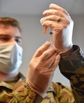 Spc. Anthony Spencer with the Tennessee National Guard prepares a COVID-19 vaccination dose for a patient at the Trousdale County Health Department June 9, 2021.