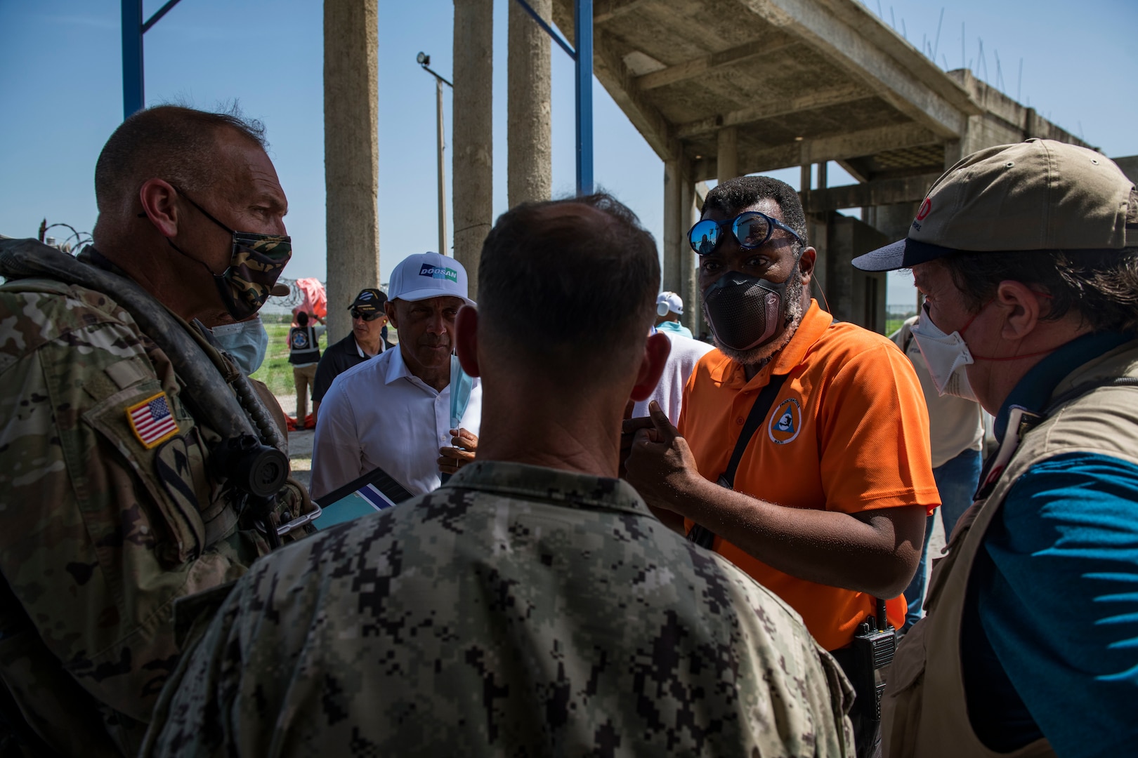 Military personnel talk in a group.