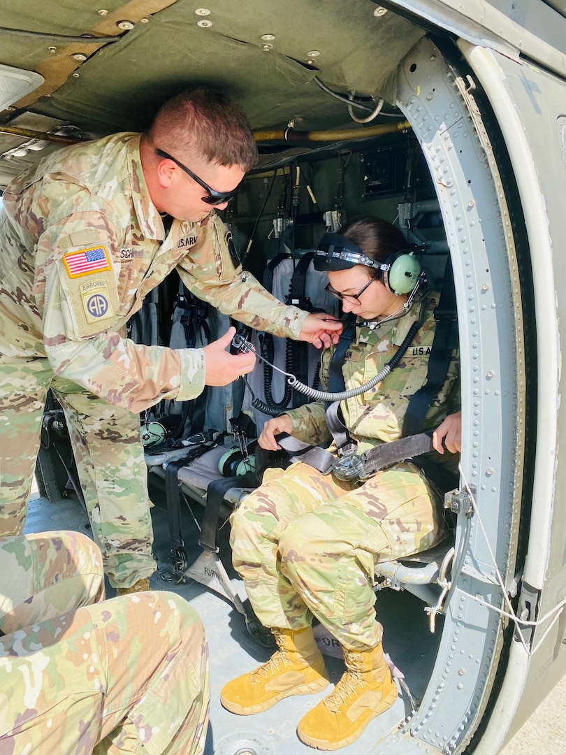 Sgt. 1st Class Axle Shultz, G3 Air noncommissioned officer in charge, assists Cadet Alexandra Andrick with her headset before an orientation flight of the Fullerton Box at the Joint Readiness Training Center and Fort Polk during her Nurse Summer Training Program.