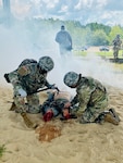 Pfc. Steven Ndong (left) and Pfc. Megan Schindler (right), 115th Field Hospital, 32nd Hospital Center, conduct tactical casualty care during a community relations engagement with Tony Kittrell, CEO, Advent Comments, at the Joint Readiness Training Center medical range, at Fort Polk, La., on Aug. 13.