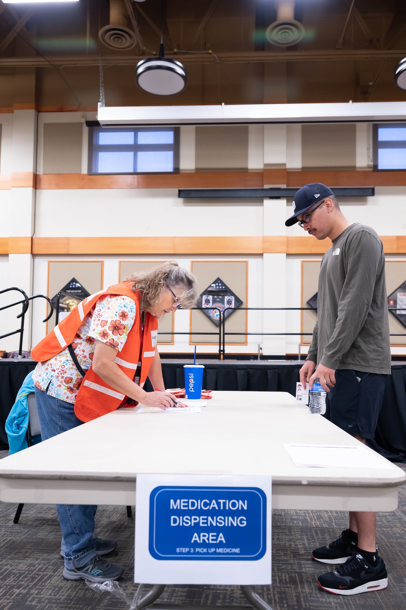 Sherry Morgan, left, 341st Healthcare Operations Squadron pharmacy technician, simulates distributing medication to Senior Airman Andy Jauregui, right, 341st Missile Security Forces Squadron defender, Aug. 19, 2021, at Malmstrom Air Force Base, Mont.