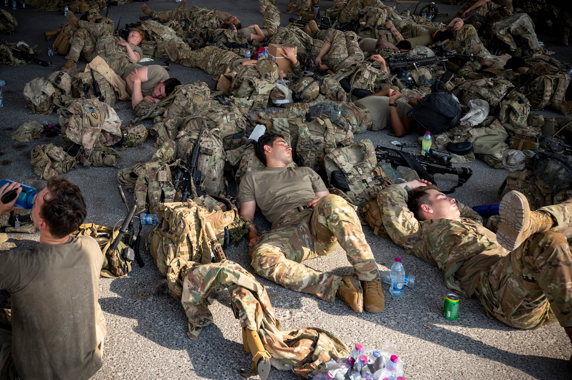 Service members wait outside of the Personnel Support for Contingency Operations area to inprocess immigrations Aug. 18, 2021, in Southwest Asia.