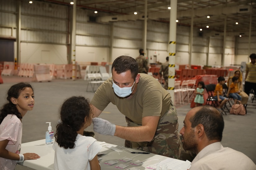 Pfc. Logan Taylor, combat medic, 811th Hospital Center, administers a Covid-19 test to an Afghan Special Immigrant at Camp As Sayliyah, Qatar, Aug. 20, 2021. Afghan Special Immigrants have the option to receive a Covid-19 vaccination. (U.S. Army photo by Sgt. Jimmie Baker)