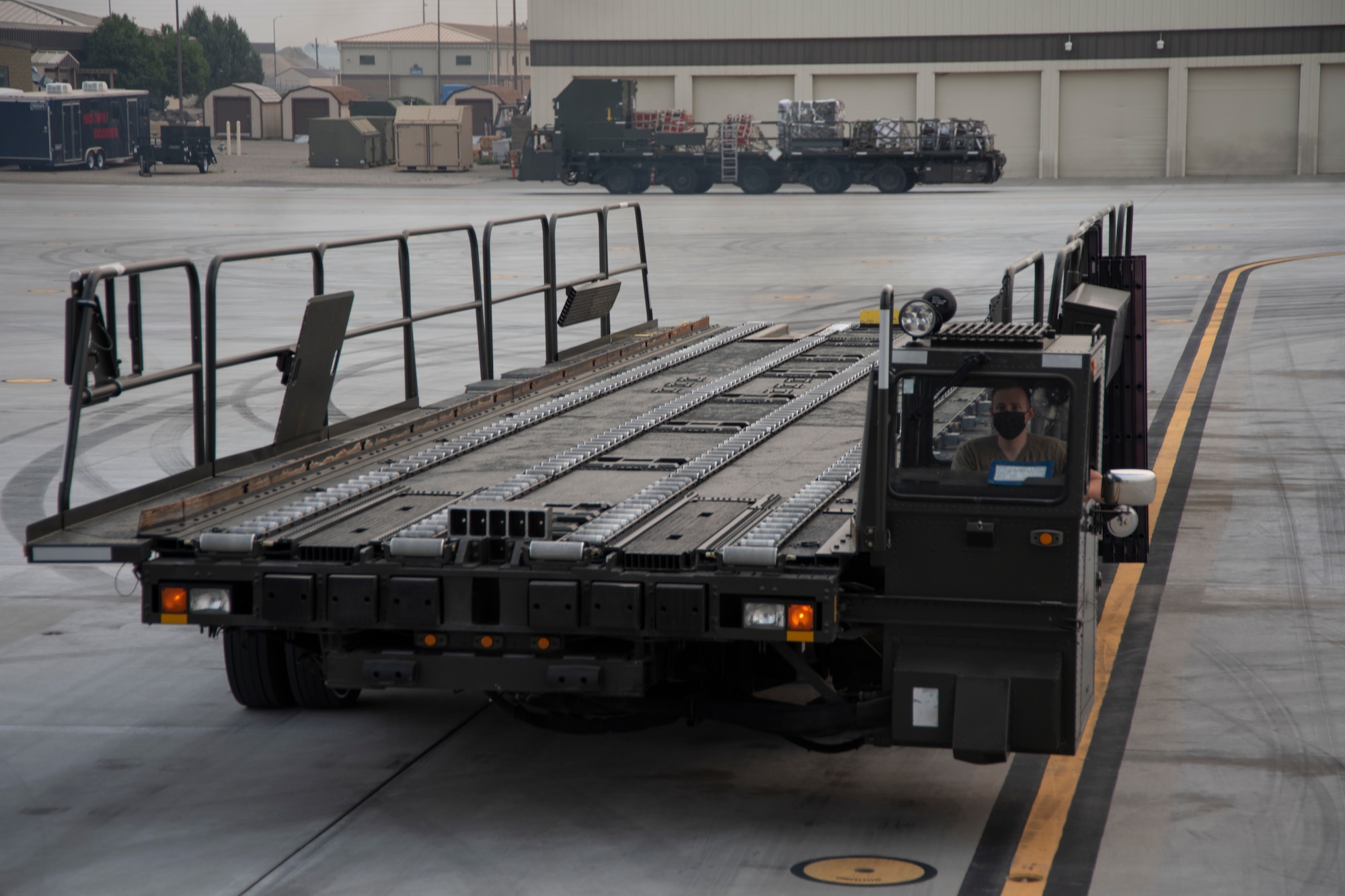 An Airman drives a 60K Tuner on a flight line.