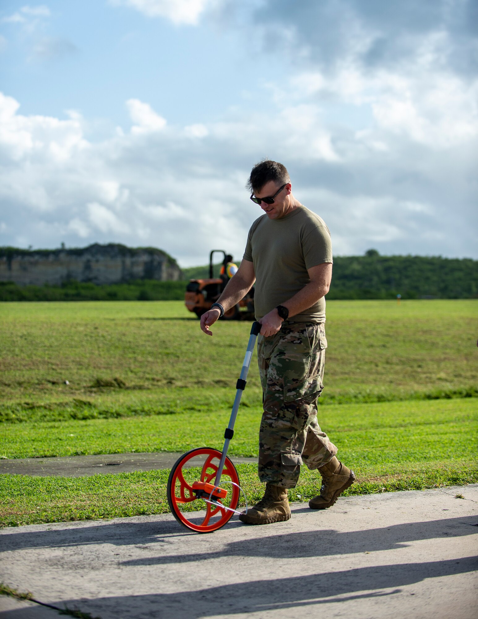 U.S. Air Force Tech. Sgt. Jeff Allen, 136th Contingency Response Flight, Texas Air National Guard, measures the width of a taxiway using a measuring wheel in St. Croix, Virgin Islands, Aug. 17, 2021.