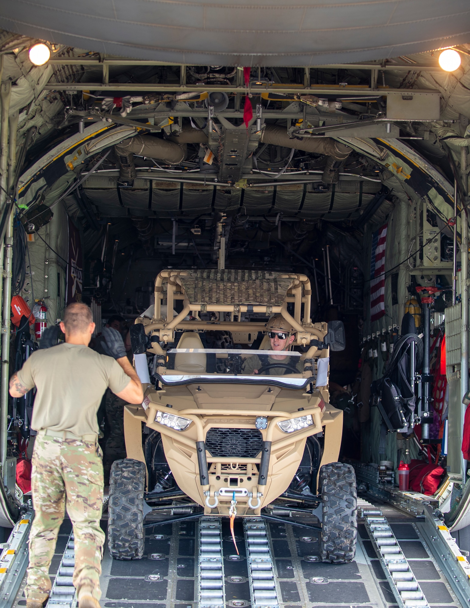 U.S. Air Force Senior Master Sgt. Nathan Sole, left, 109th Airlift Squadron provides directions to Tech. Sgt. Ross Wehrle, 133rd Contingency Response Flight, Minnesota Air National Guard, right, as he backs the light tactical all-terrain vehicle (MZRZ) onto a C-130 Hercules from the Minnesota Air National Guard in St. Croix, Virgin Islands, Aug. 17, 2021.