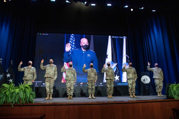 Military members raise their hands to reaffirm their oath to the Space Force