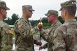 Kentucky Army National Guard Maj. Jason Mendez, commander of the 1st Battalion, 149th Infantry Regiment, hands off the NCO Sword to Command Sgt. Maj. Will Long, the incoming senior non-commissioned officer, during a change of responsibility ceremony held at Camp Atterbury, Indiana, July 31, 2021. (U.S. Army National Guard photo by Staff Sgt. Paul Glover, released)