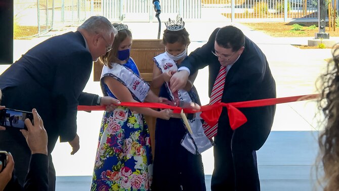 Kevin Cordes, the Muroc Joint Unified School District superintendent, gets help cutting the ribbon to officially open Irving L. Branch Elementary School and William A. Bailey Elementary School at Edwards Air Force Base, California, Aug. 13. (Air Force photo by Maygan Straight)