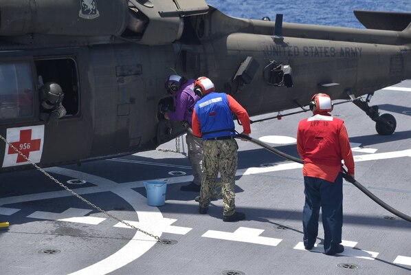 Sailors assigned to the Spearhead-class expeditionary fast transport ship USNS Burlington (T-EPF 10) refuel a U.S. Army UH-60 Blackhawk helicopter on the flight deck, Aug. 21, 2021.